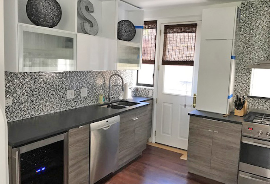 In this Gold Coast reno, Christine says, “We ripped out the dated kitchen and brought it up to date with sleek cabinets, a waterfall edge on the island, brushed black absolute granite countertops, and a hood over the range.  The result was a thoroughly modern makeover.”
