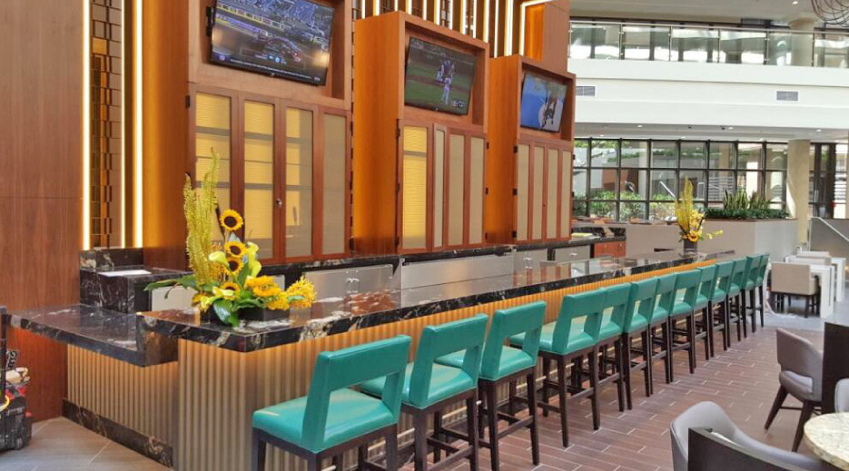 Mitered black marble bar includes an ADA counter (at left in photo), designed, fabricated and installed for a local sports bar.
