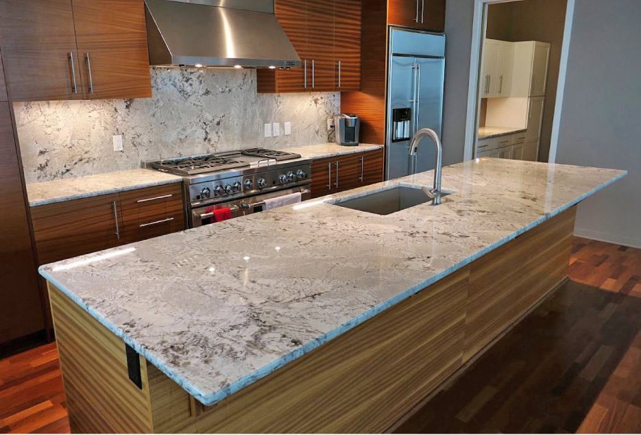 This full-length island is complemented by a matching full-height backsplash. Crowley’s Granite specializes in rapid fabrication-to-install work for high-end residential and builder clients.