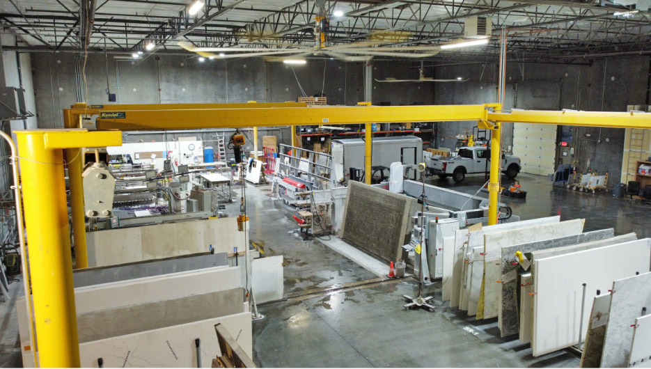Overhead view of fabrication station end of the shop shows loading area for installation truck, and the configuration of the R-track rails.