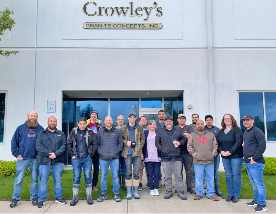 Crowley’s Granite team gathers in front of the 12,000 square-foot facility. The large windows also let light into the shop area.