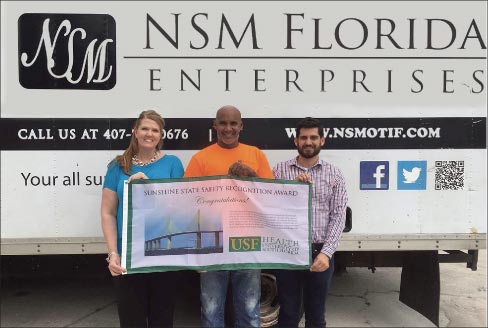 Karen Rothenberg, Omar Gonzalez, and Stephen Fiumara of NSM Florida Enterprises with their award banner.