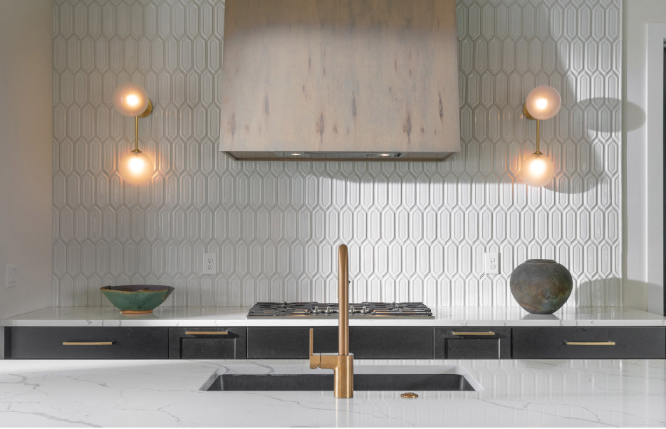 Open plan residential kitchen features Calacatta Laza polished quartz with full-sized eased double waterfall island.