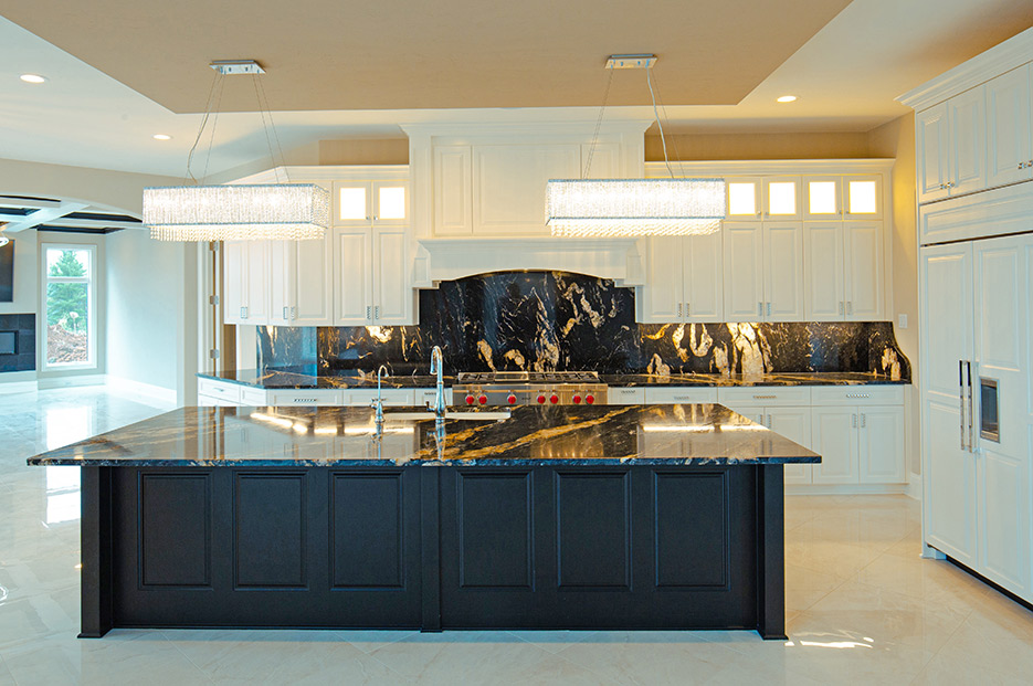 Palatial, open-plan kitchen features a full-slab island and matching full-height splash of Titanium granite.