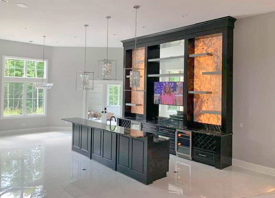 Titanium granite bar and built-in entertainment center with backlit panels of Onyx.