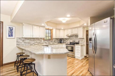 Skeeles Manufacturing kitchen remodel features Venetian Gold granite countertops with glass subway tile backsplash.