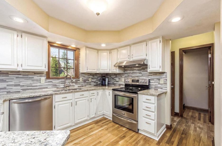 Venetian Gold granite kitchen with full-height glass tile backsplash.