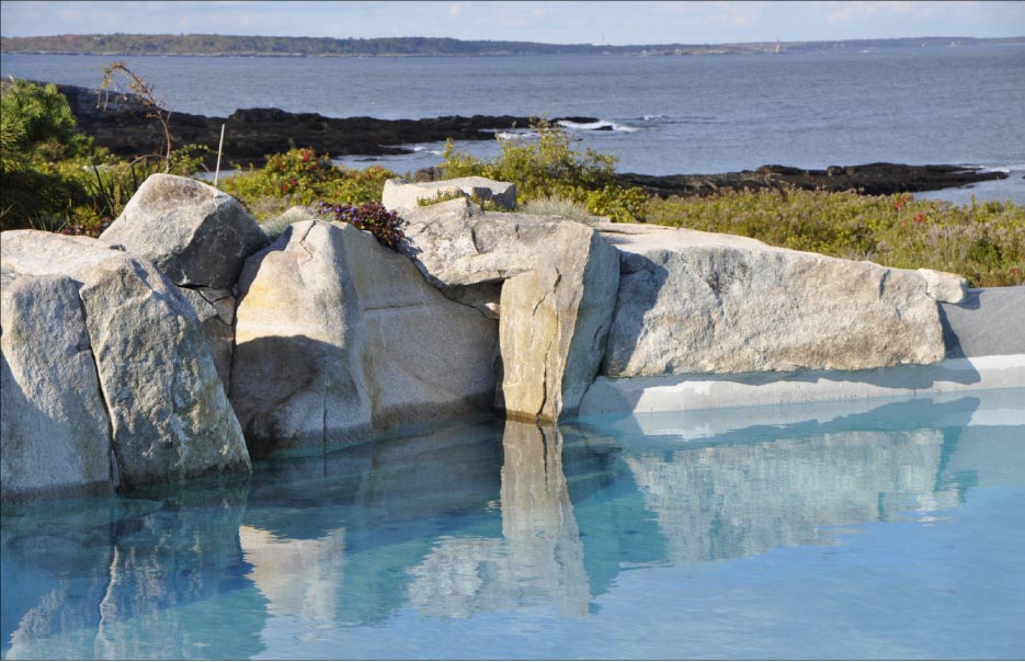 Local stone was used to create this naturalized outcropping for a waterfall and swimming pool retaining wall in Cape Elizabeth, Maine.