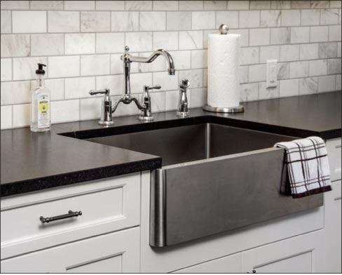 A stainless steel apron sink will complement Cambrian Black granite countertops.
