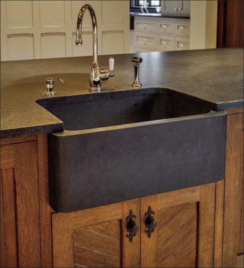 Warm, traditional wood cabinetry and oiled bronze fixtures and hardware goes perfect with a carved  granite sink. This stonework is by Stone Age Marble.