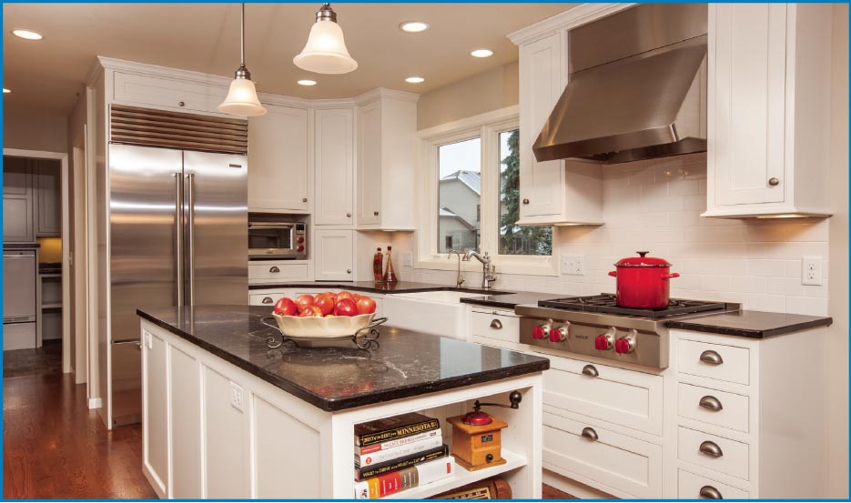 Classic white and stainless steel chef’s kitchen features a large Caesarstone island and a Wolf range top.