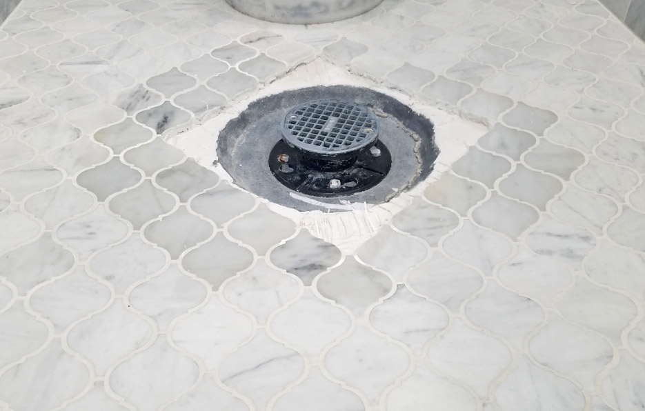 The cause of the moisture discoloration was not clogged weep holes, but an improper assembly/system for marble.