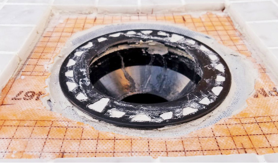 Integrated bonding flange drains create a little dam around the drain opening; not what you want in your marble tile shower installation.