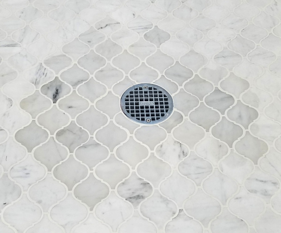 An example of moisture discoloration around a drain in a marble shower floor – a common problem arising from faulty construction.